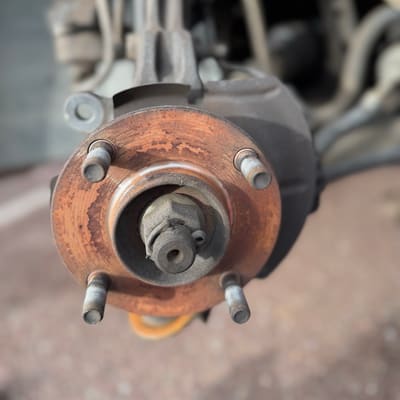 Bare wheel hub with the rotor removed, the mounting face covered in rust